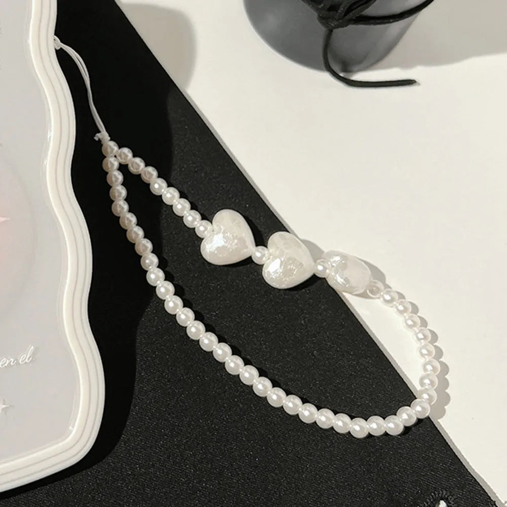 Clear iPhone case with a raised 3D ice bow design and a white love lanyard attached.