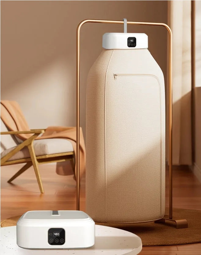 White cylindrical portable laundry drier dryer with remote control on a countertop.