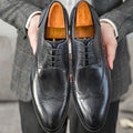 Men's black pointed toe Oxford leather shoes with carved brogue patterns and low heel