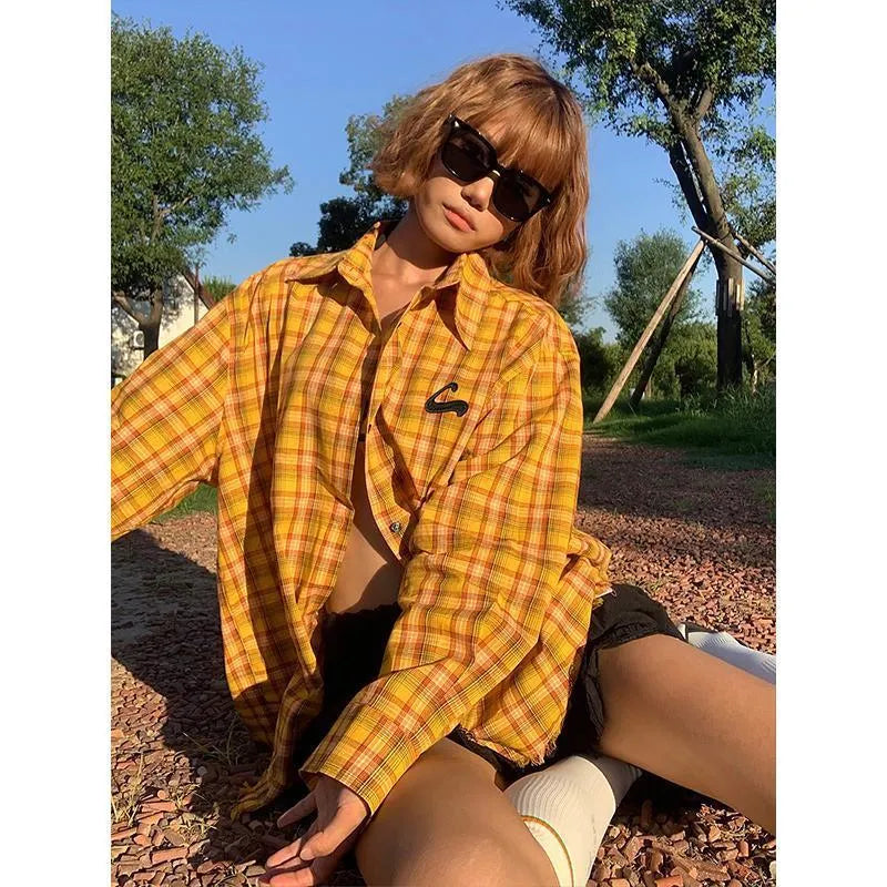 Dopamine yellow and black plaid shirt with a loose cardigan style fit on a hanger.