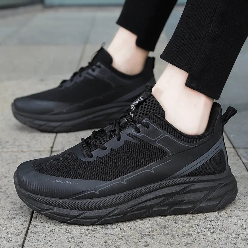 Men's black thick-soled anti-skid lace-up running sneakers with round toe and rubber sole on grey background