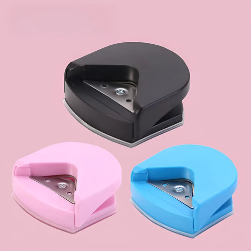 Black, blue, and pink plastic and metal business card corner cutter tool on a white background.