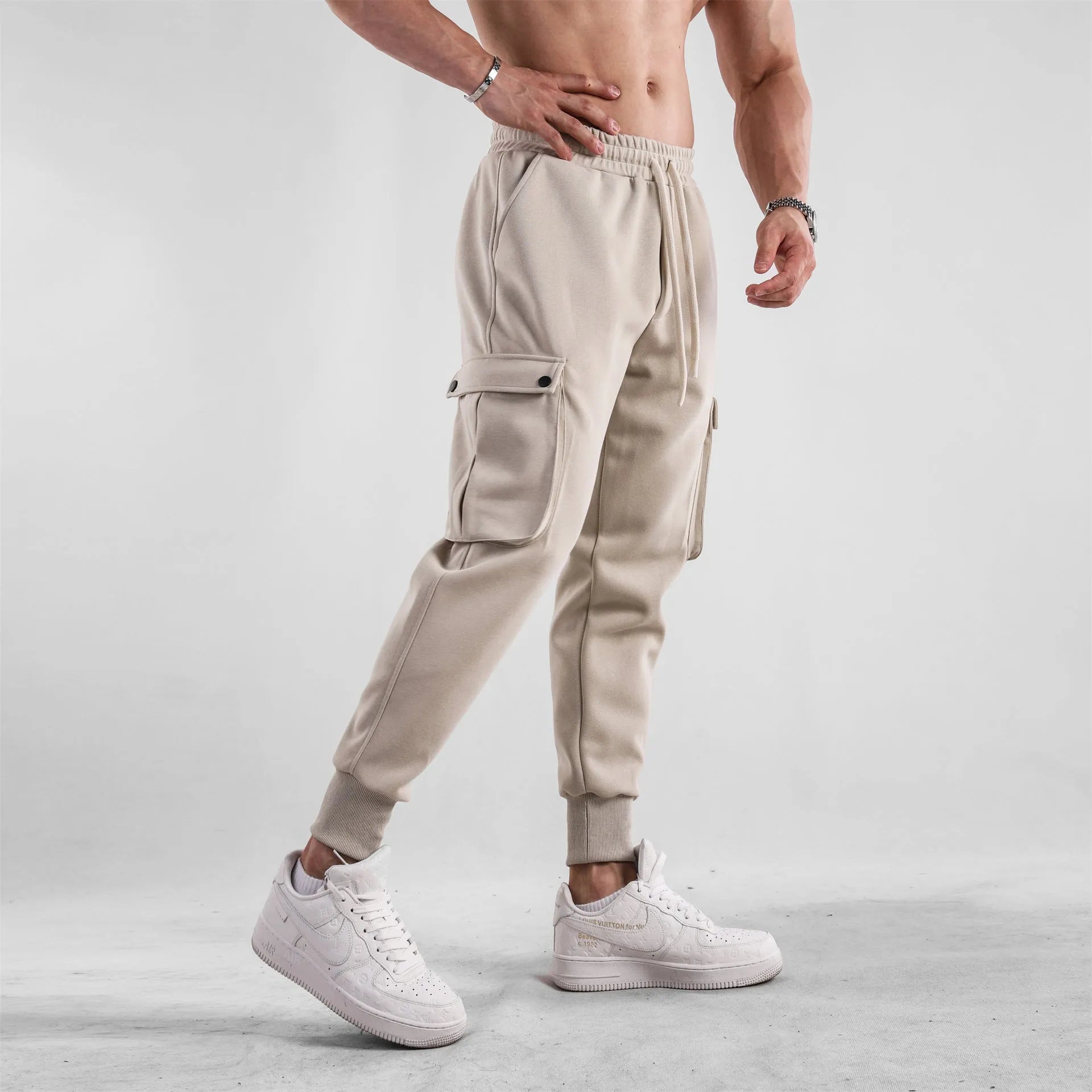 Men's loose-fit apricot coloured cotton sports trousers with an ankle tie and side pockets on a neutral background.