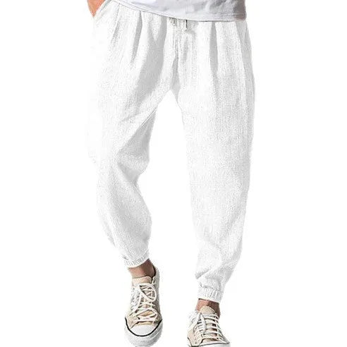 Men's loose-fit light green cotton casual trousers with a banded ankle cuff on a plain background.