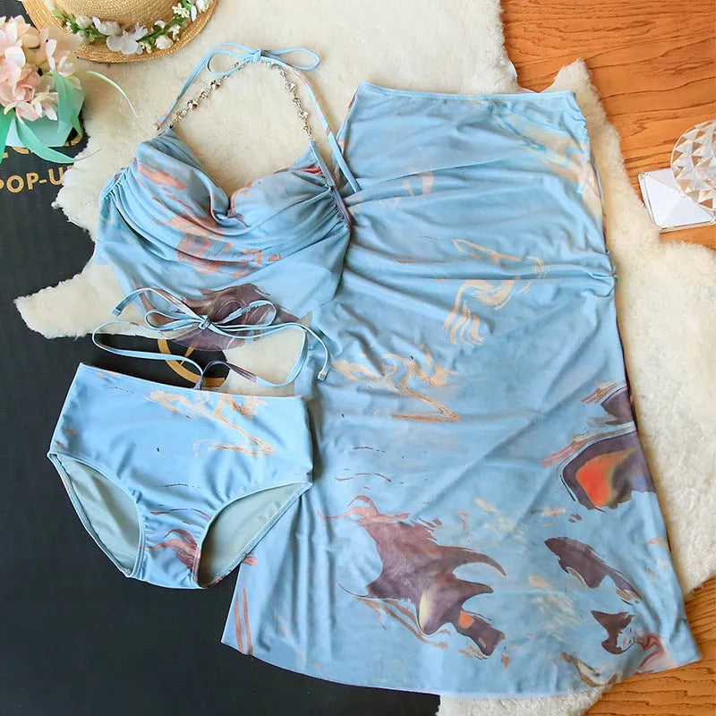 Women's blue printed three-piece bikini set with triangle top featuring steel wire support and a detachable skirt.