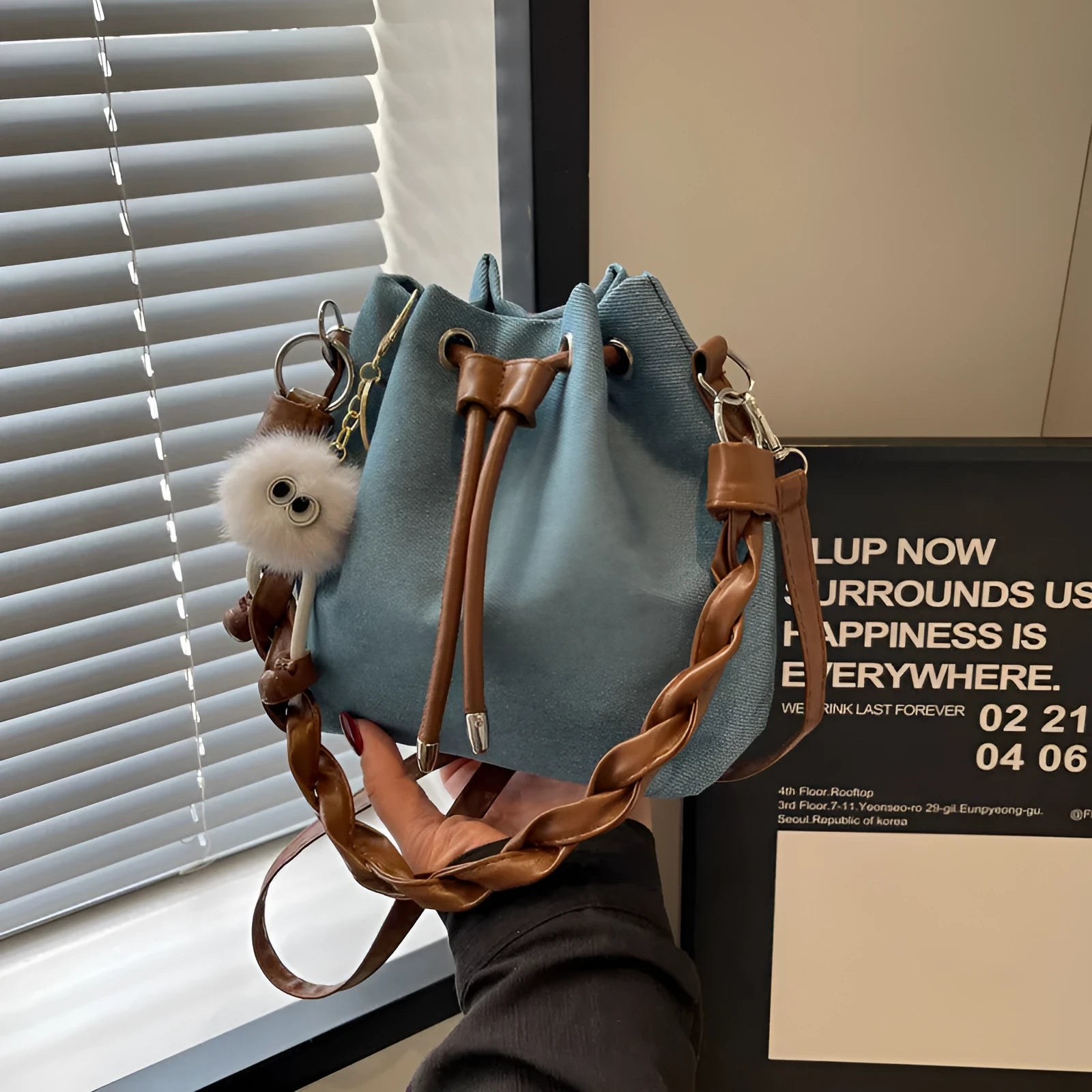 Blue one-shoulder cross body bucket bag with synthetic leather lining and sandwich pocket
