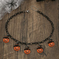A Halloween necklace with an acrylic pumpkin and skull pendant on a clavicle chain