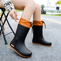 Women's solid colour PVC rain boot with non-slip sole in apricot, black, brown, or pink.