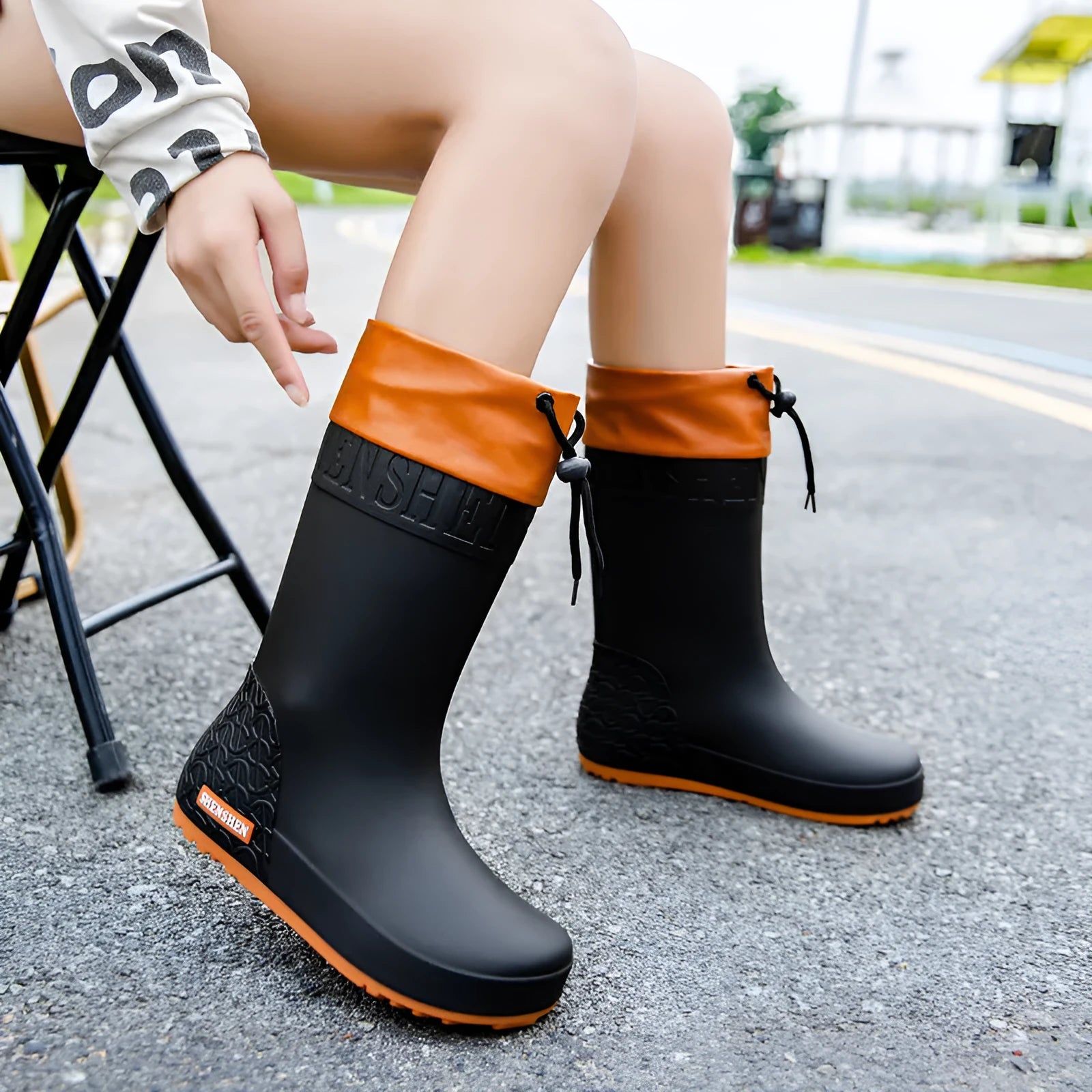 Women's solid colour PVC rain boot with non-slip sole in apricot, black, brown, or pink.