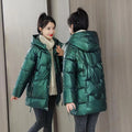 Women's loose fit hooded winter jacket in black, shown on a model, featuring a front zip and acrylic lining.