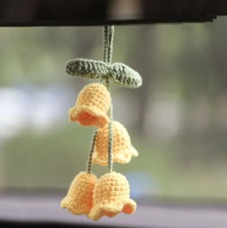 Green and white knitted wool car plant ornament with hanging rope.