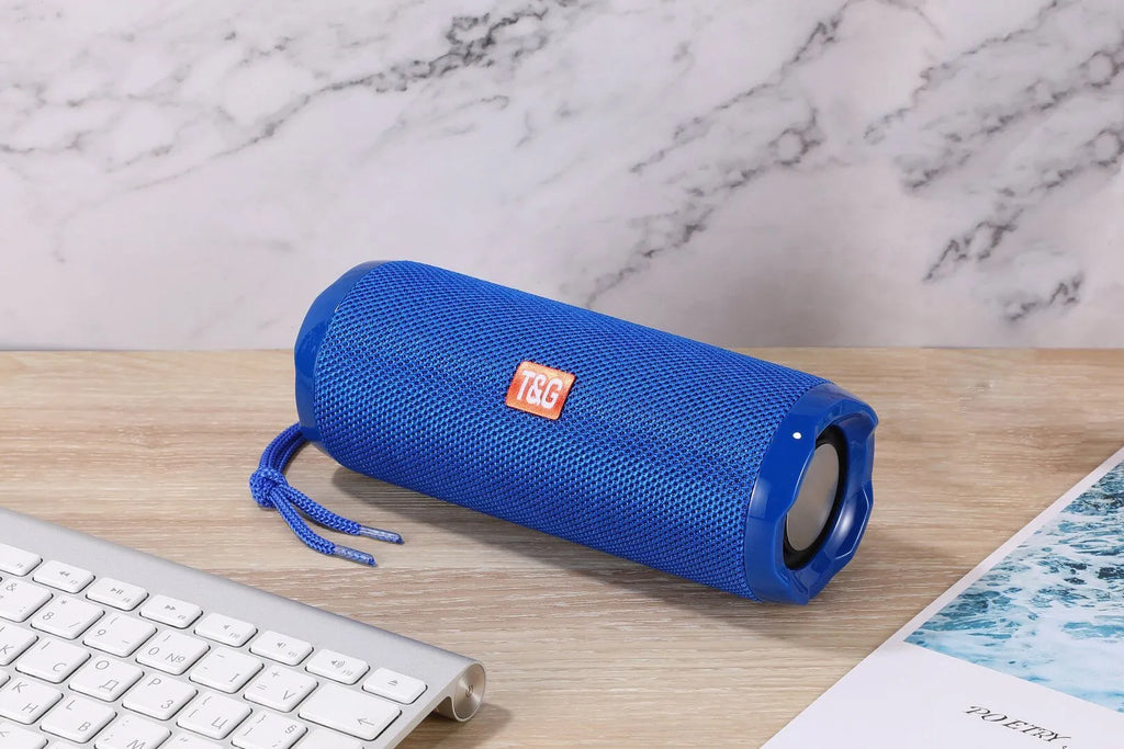 Fabric-covered portable Bluetooth speaker showing the integrated card holder slot, displayed in the camouflage colour variant.