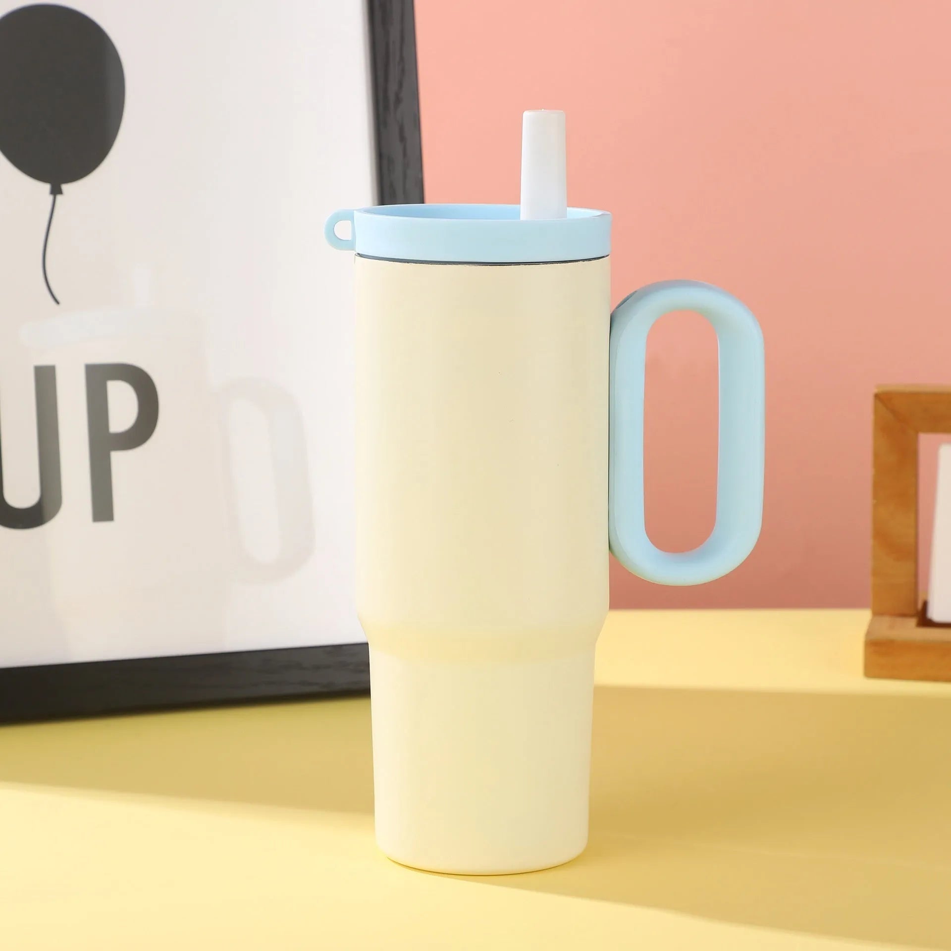 A large insulated portable cup with a handle, shown in multiple colour options.