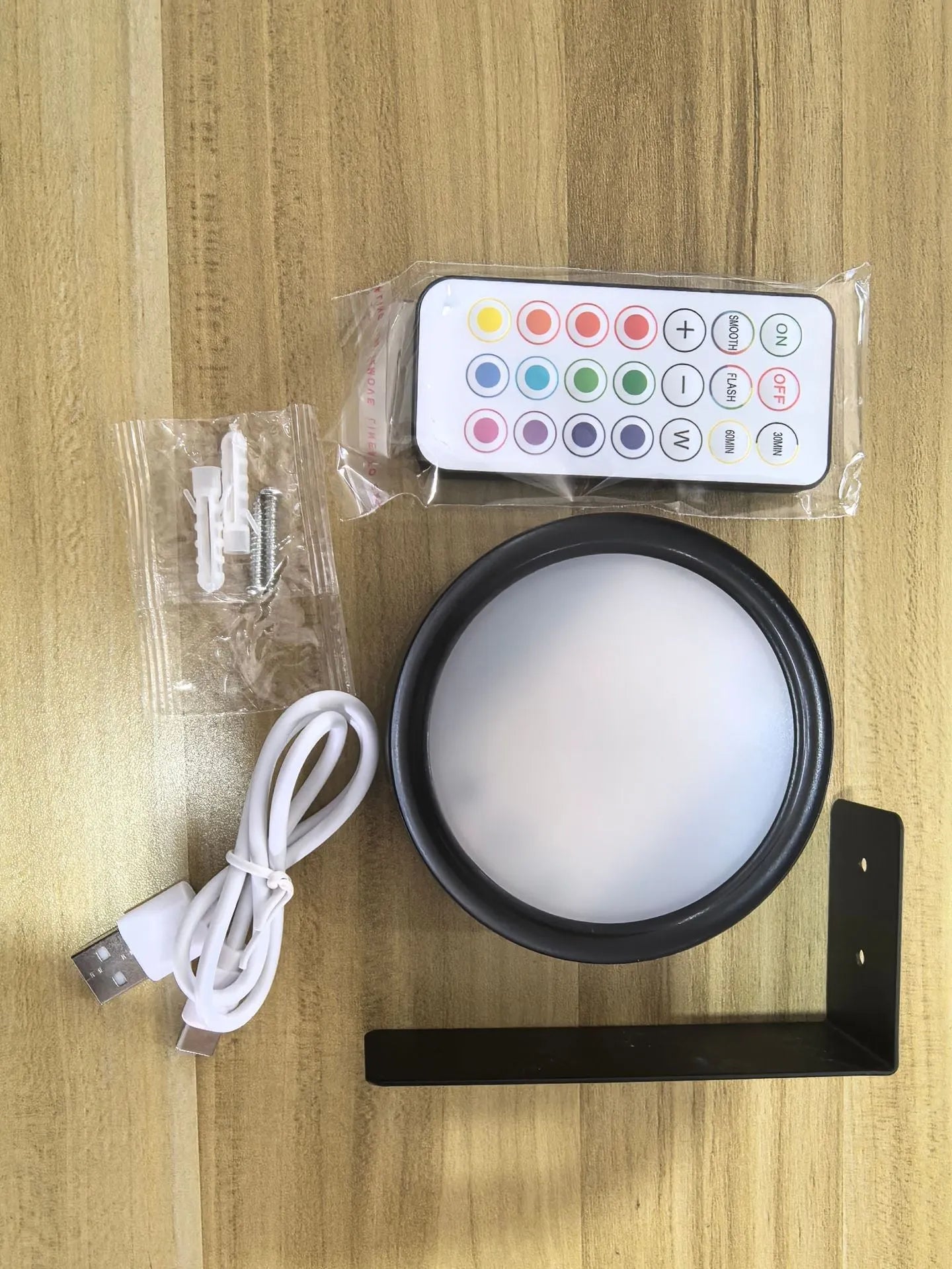 Black magnetic wireless LED lamp with remote control mounted next to a painting on a wall.