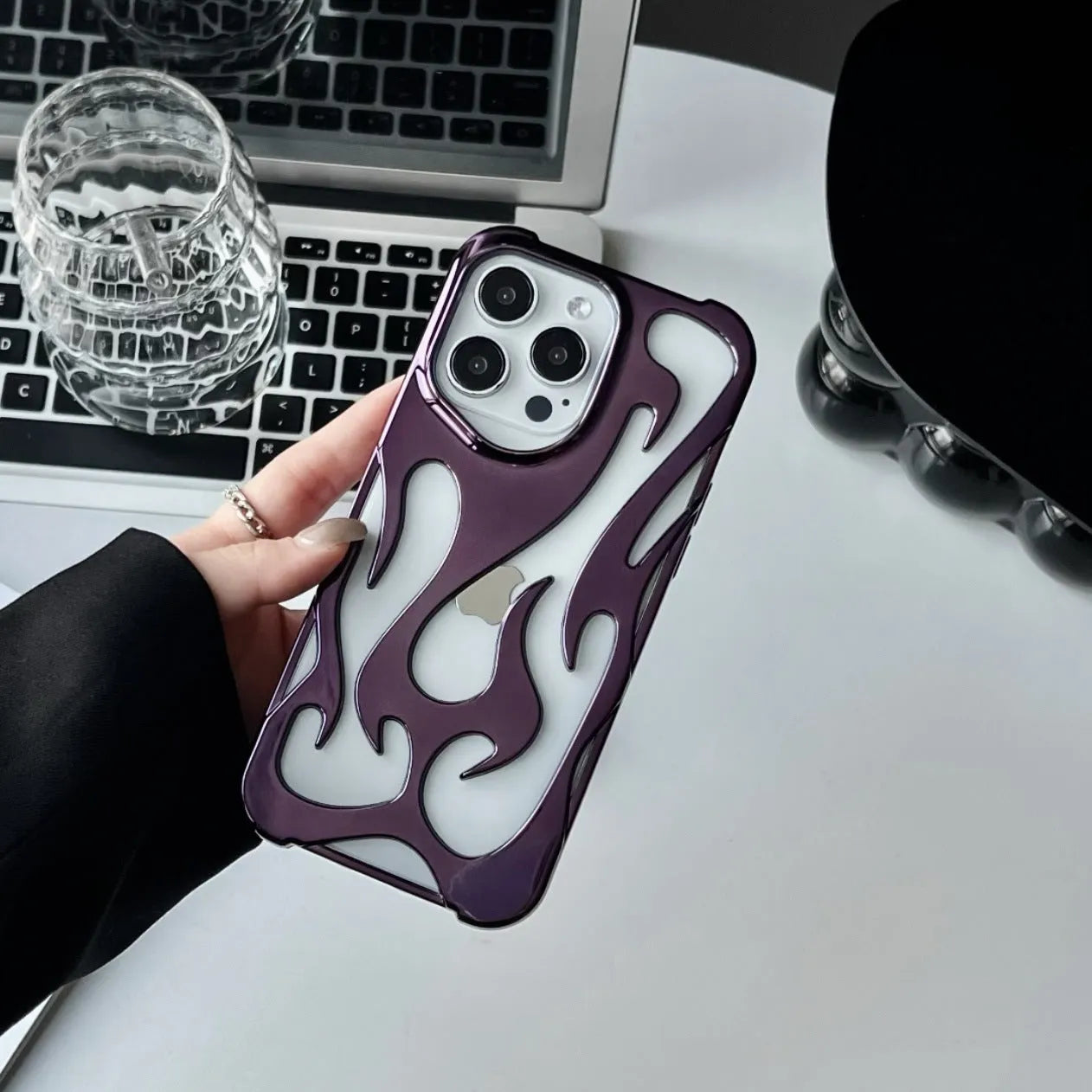 Silver electroplated iPhone case with hollow flame pattern design on a dark background