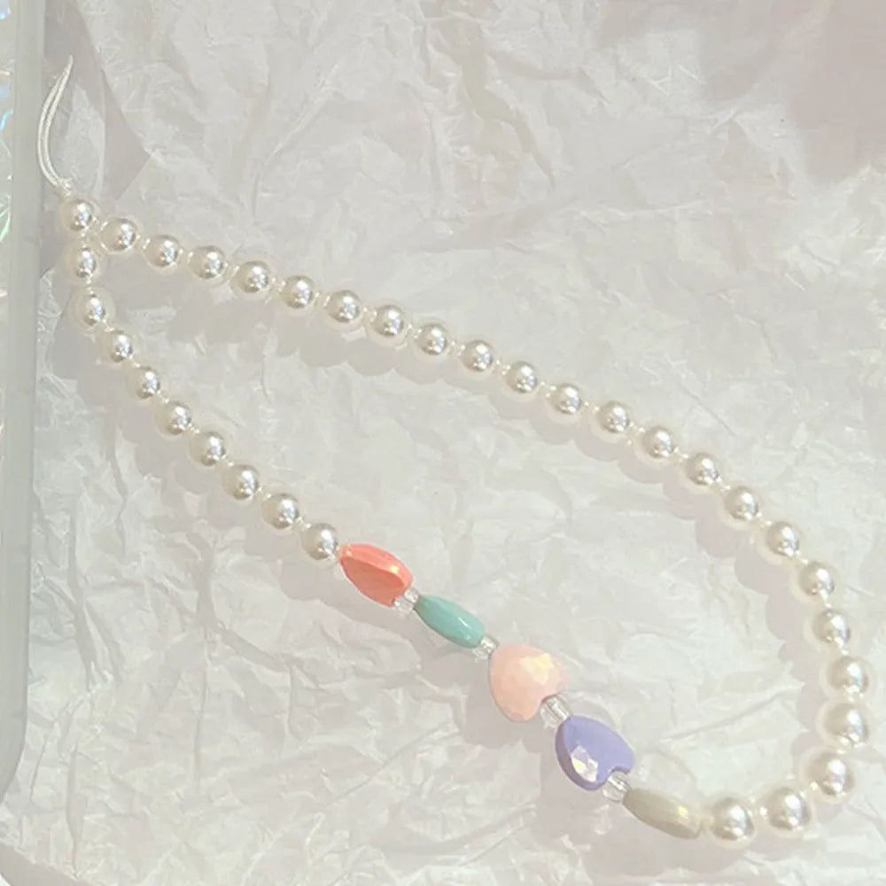 Clear iPhone case with a raised 3D ice bow design and a white love lanyard attached.