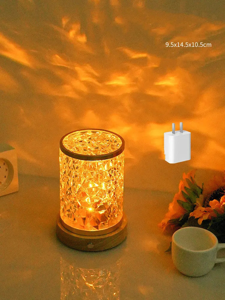 Small rotating water ripple night light on a wooden base with a USB cable.