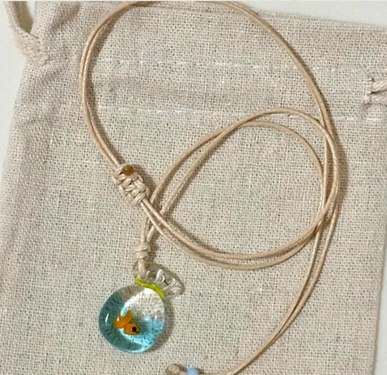 Women's necklace with coloured glaze skirt joker pendant on a beige cotton and linen chain, 45cm long.