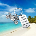 Stainless steel motorcycle-themed keychain with charm and a red flannel storage pouch.