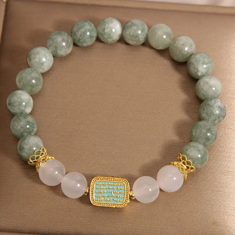 Women's oil green emerald crystal bracelet with five-piece sutra design on wrist.