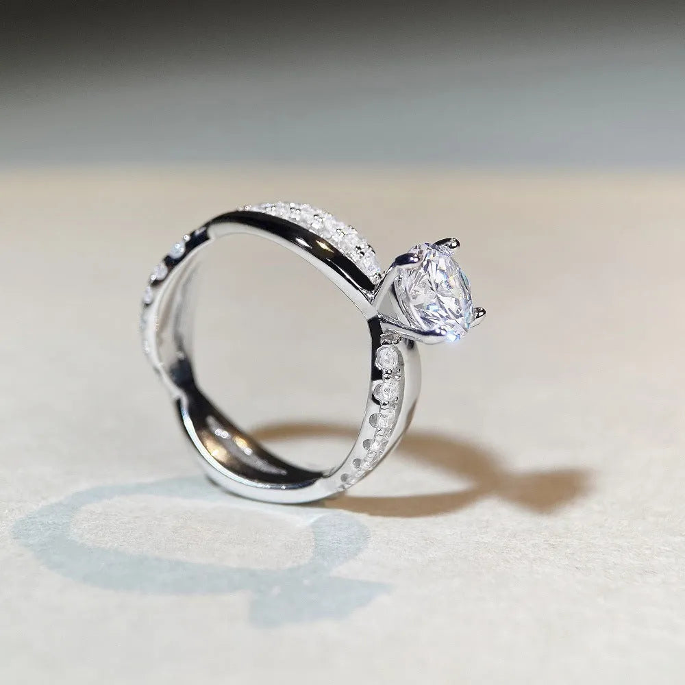 Geometric cross design silver ring with a 1 carat moissanite stone and twisted arm winding.