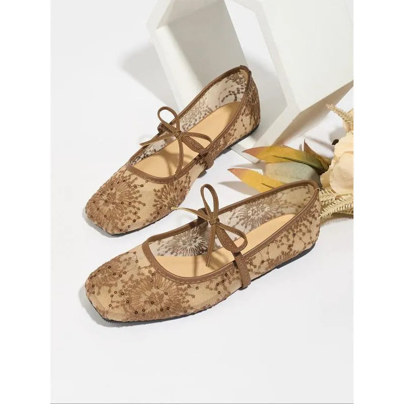 Pink flat heel Mary Jane evening shoes with lace mesh upper and rubber sole.