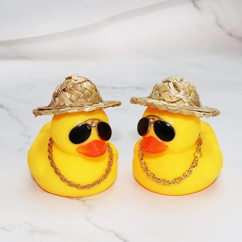 Straw hat yellow duck car ornament with adhesive gel and miniature sunglasses accessory on car dashboard
