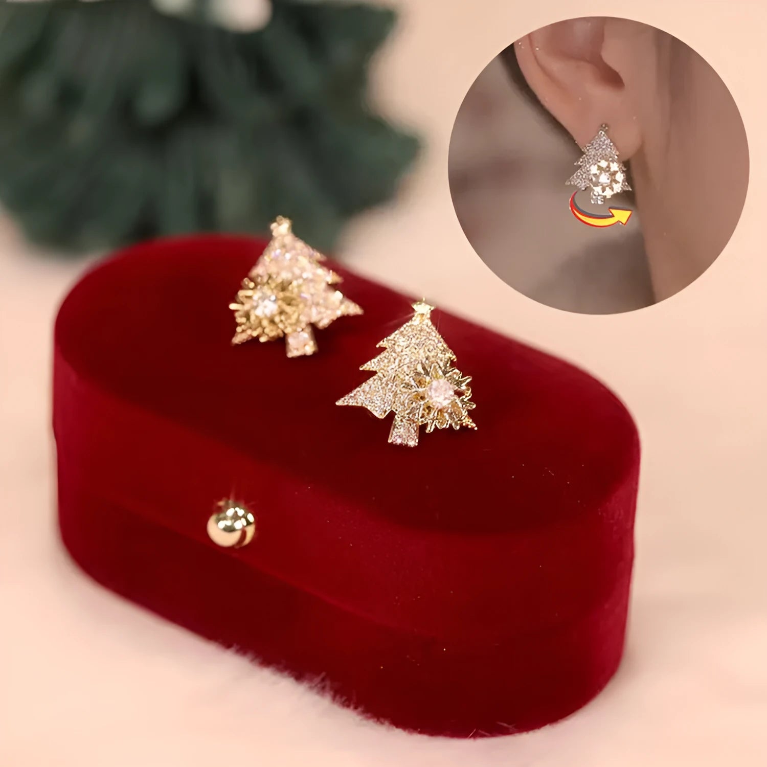 Pair of rotatable Christmas tree stud earrings with rhinestone snowflake detail in gold on a white background