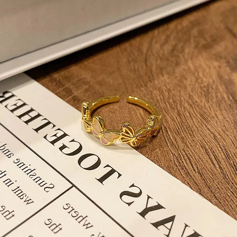Creative butterfly design women's ring in copper with oil drip finish, showing an open loop style.