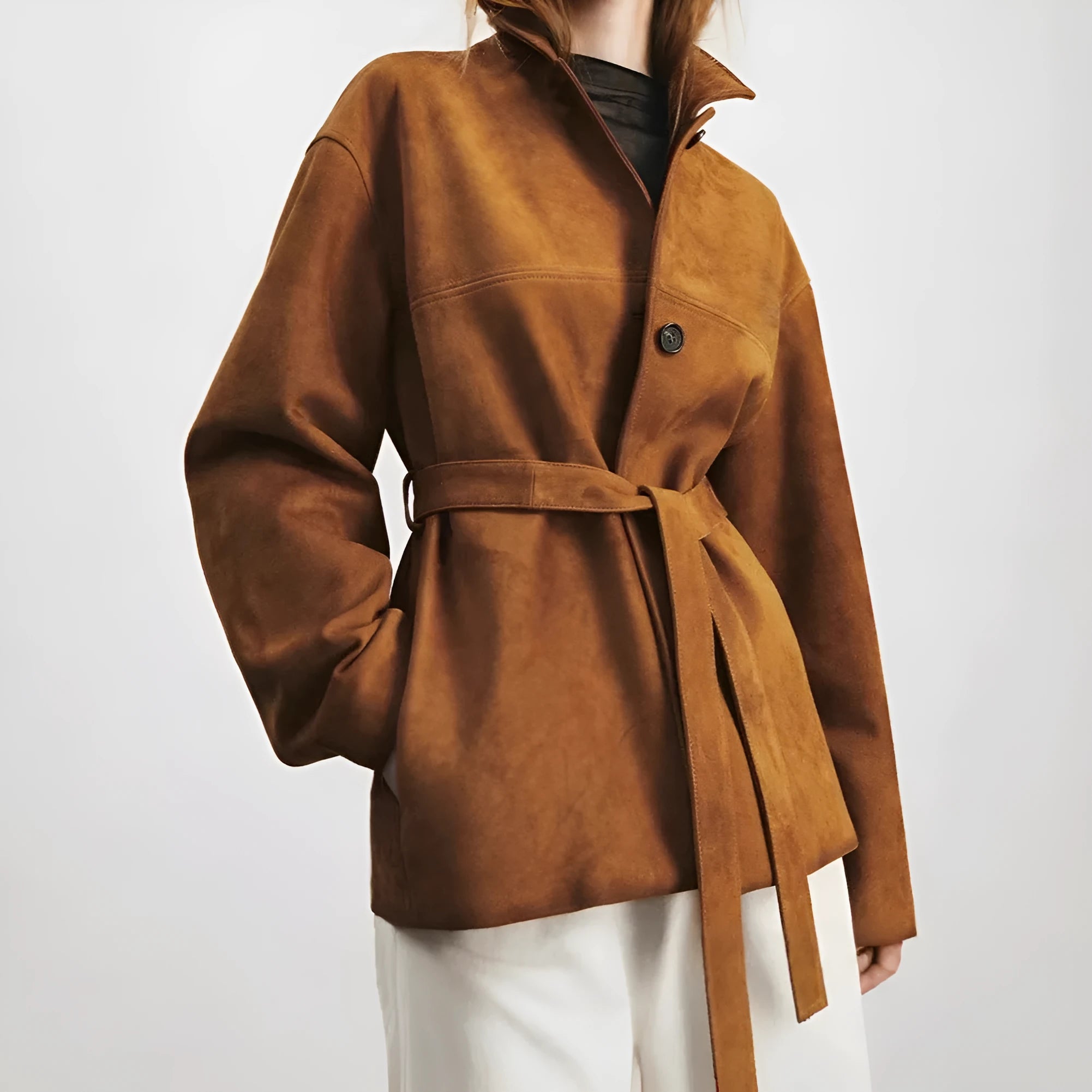 Yellow brown retro women's coat with Peter Pan collar and leather belt on a hanger.