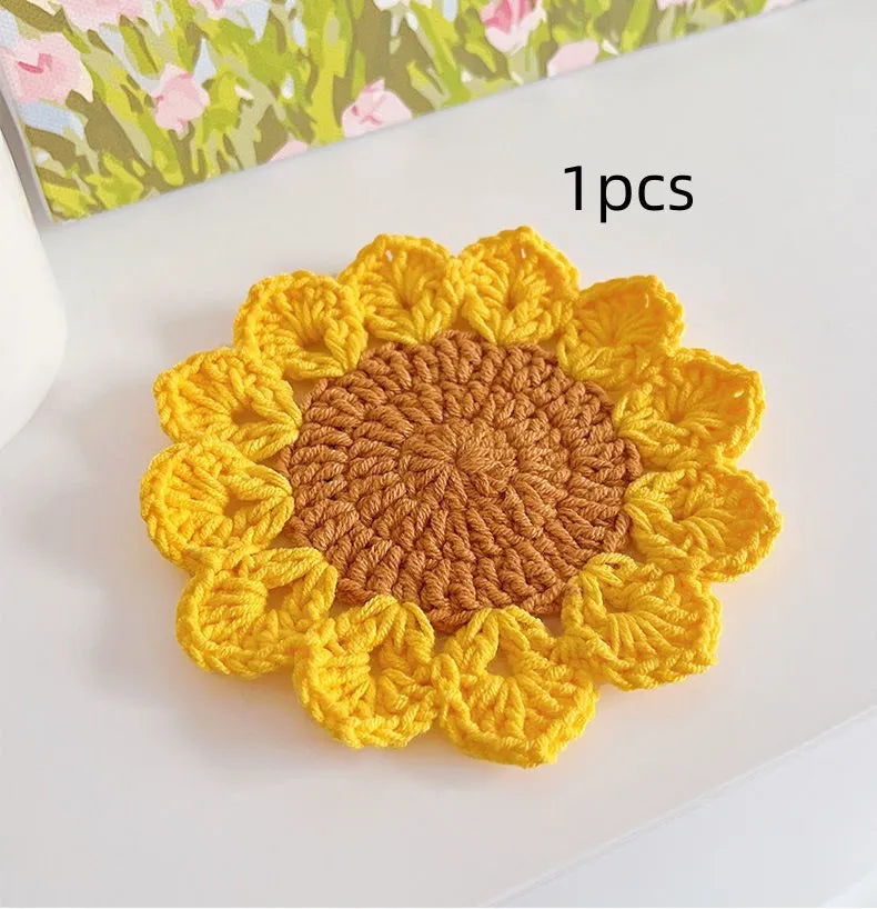Hand-woven wool coaster set for drinkware on a tabletop.