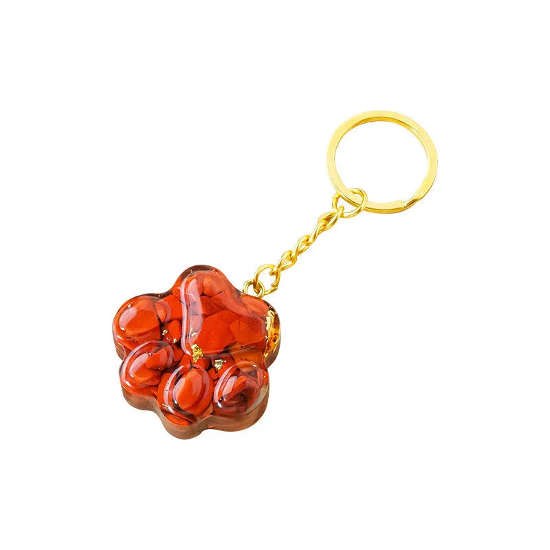 Hand-finished natural crystal cat's paw keychain pendant on a metal ring, showing detailed carving and polished stone surface.