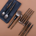 12-piece makeup brush set with wooden handles in a grey PU zip case