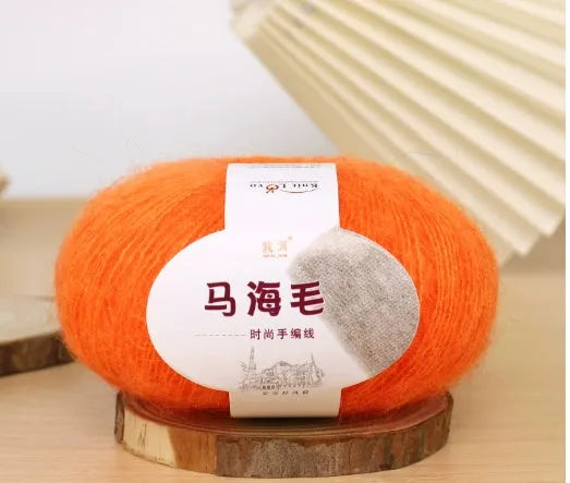 Ball of mohair yarn for DIY scarf knitting in one of 34 colours, including white, pink, blue, and green.
