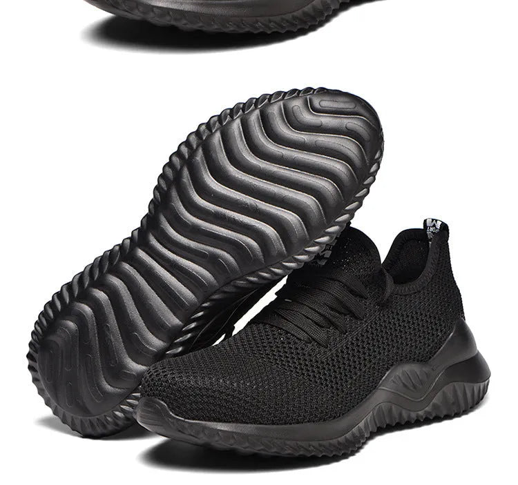 Low-cut black safety work shoes with a steel toe cap on a grey background.