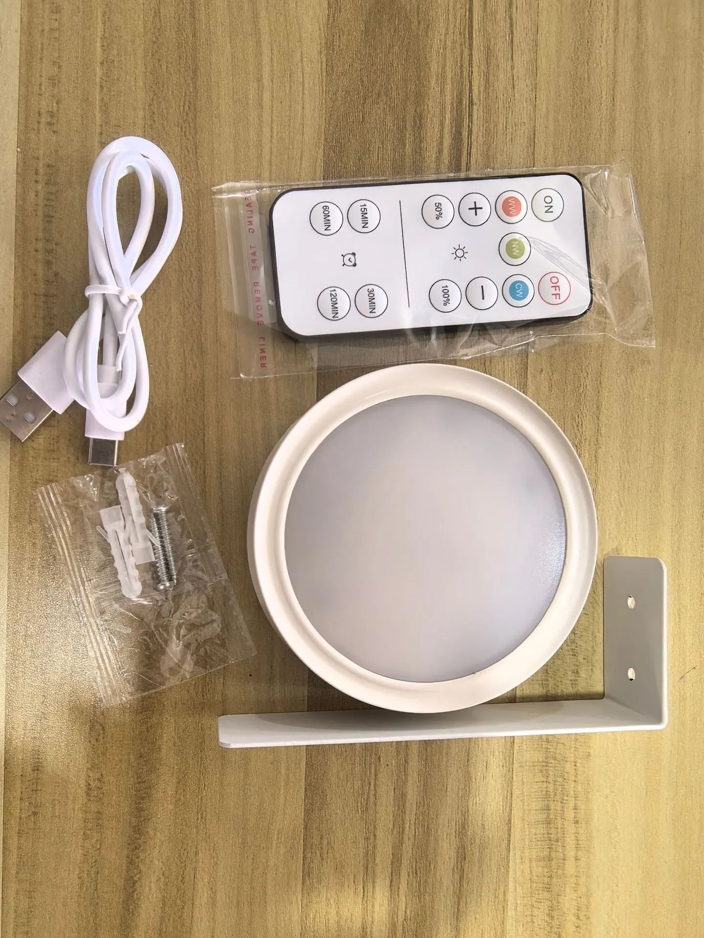 Black magnetic wireless LED lamp with remote control mounted next to a painting on a wall.