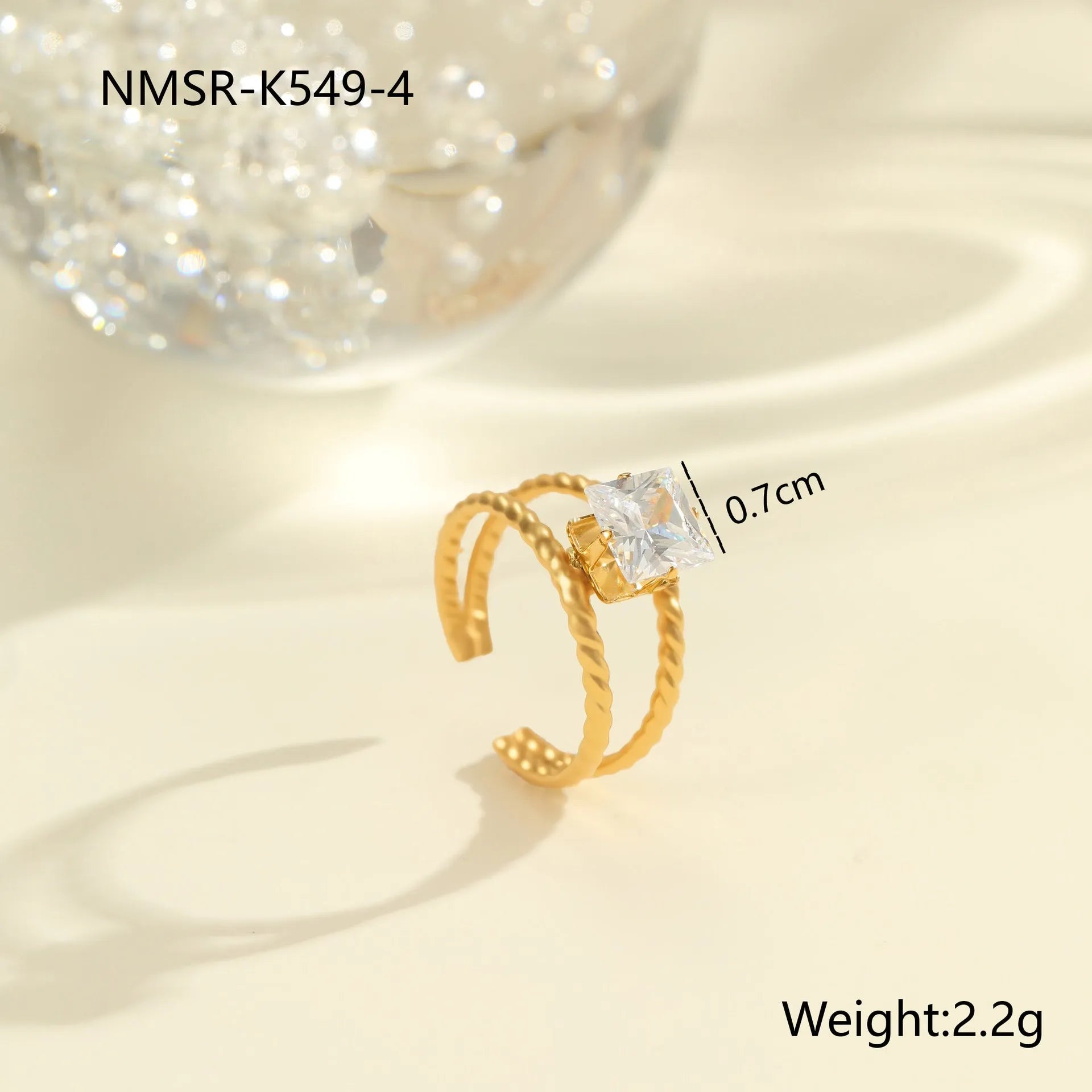 Gold electroplated adjustable ring with geometric zircon design on a stainless steel band.