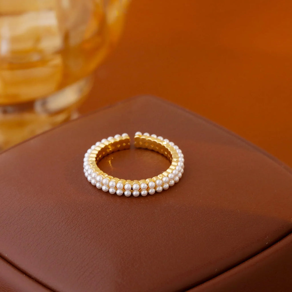 Gold electroplated pearl ring with open mouth geometric design on female hand