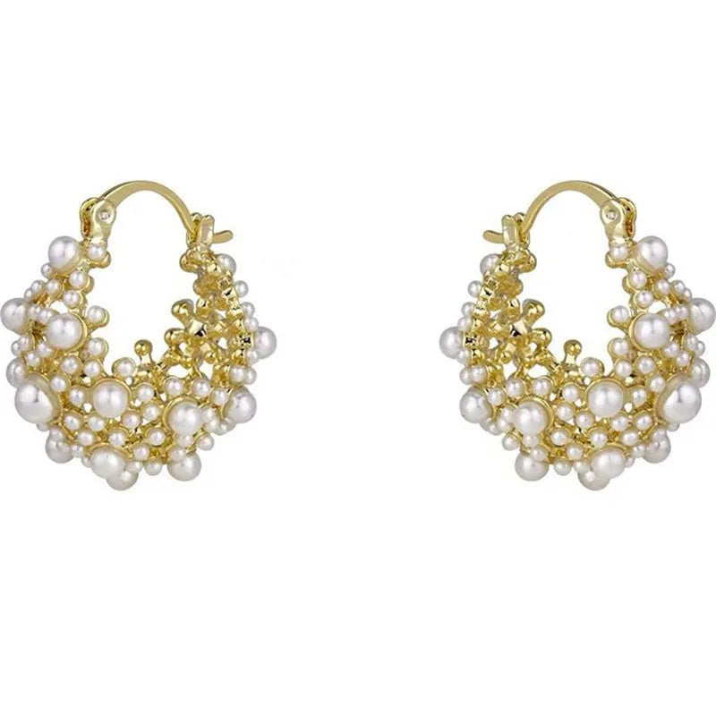 A pair of gold-coloured copper flower basket earrings with pearl inlay and small rice-shaped bead details.