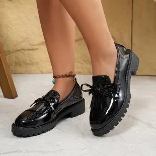 Women's brown and black flat loafers with a bow detail on the artificial PU upper.