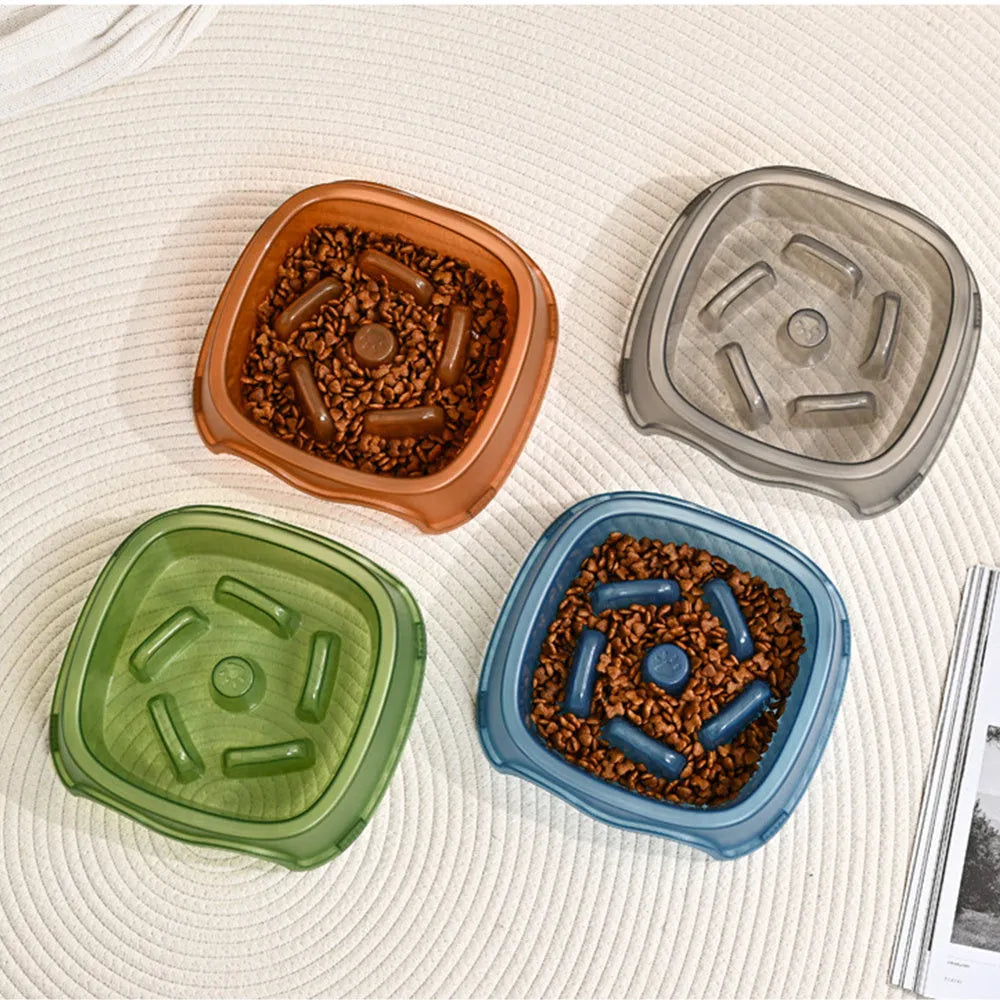 Blue plastic slow-feed dog bowl on a floor to prevent choking.