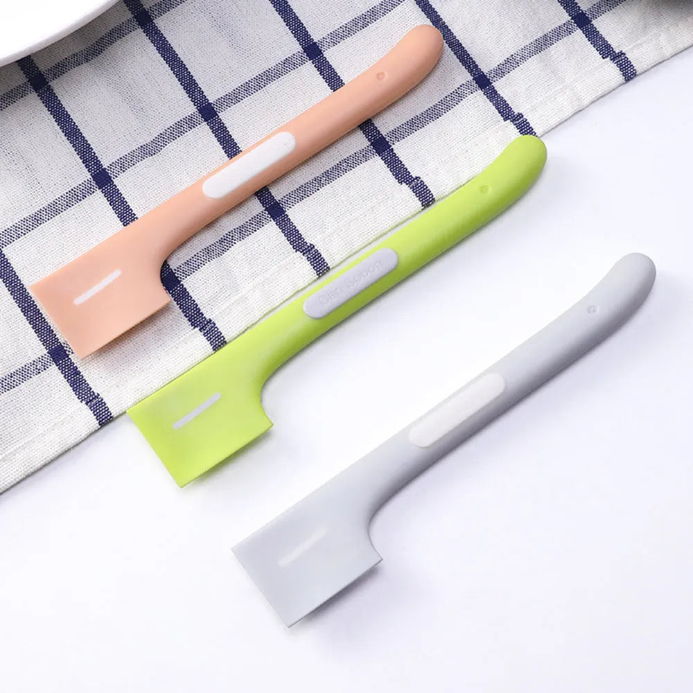 Green long-handled TPR spoon for scooping wet pet food from a tin.
