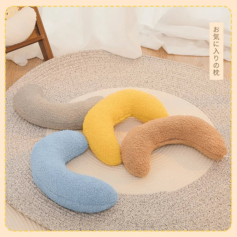 Blue U-shaped cat pillow with adjustable fabric collar on a sofa
