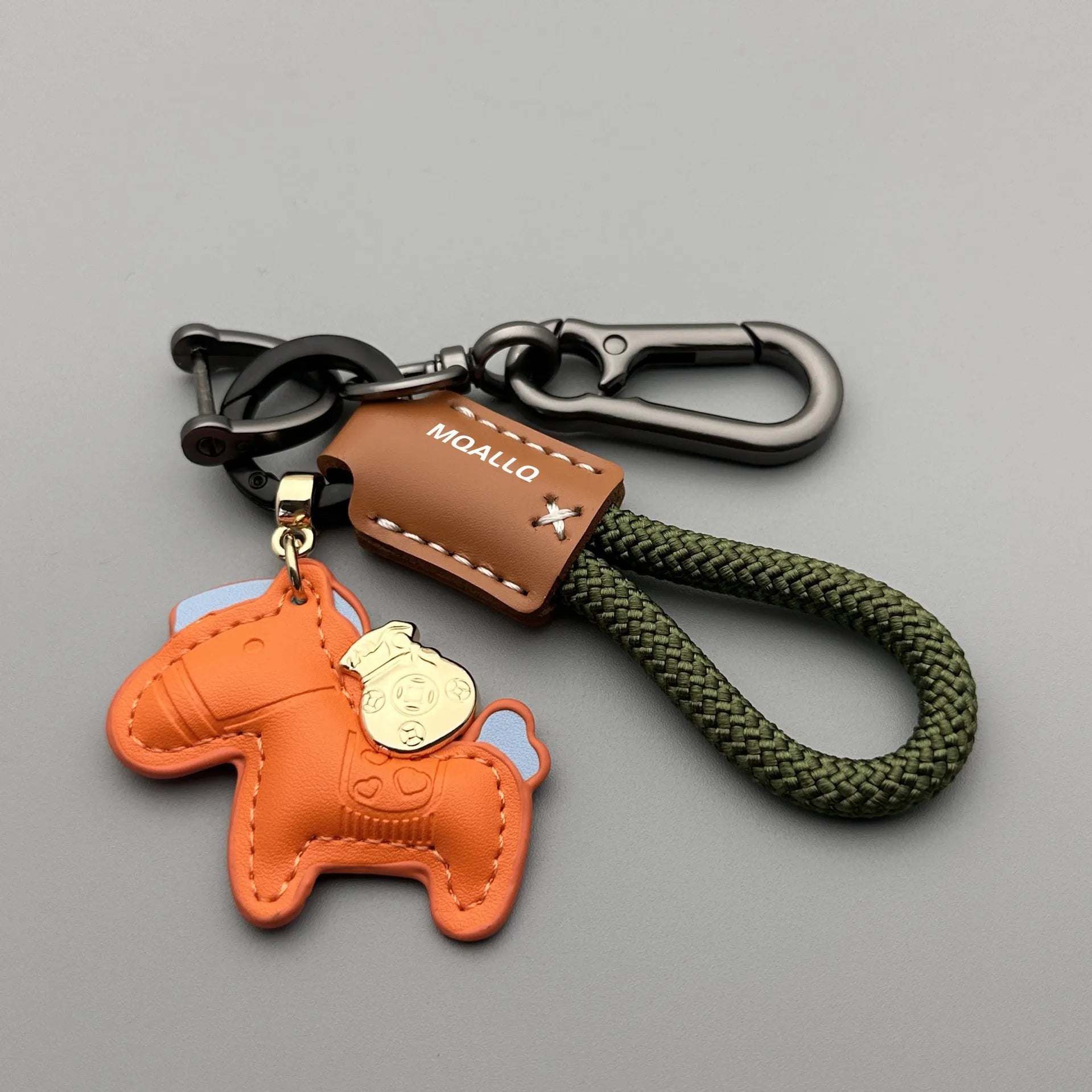 Handmade brown cowhide leather key ring with a zinc alloy pendant charm on a green flannel rope.