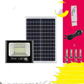 Black Cornucopia solar-powered LED flood light mounted on a garden wall with remote control.