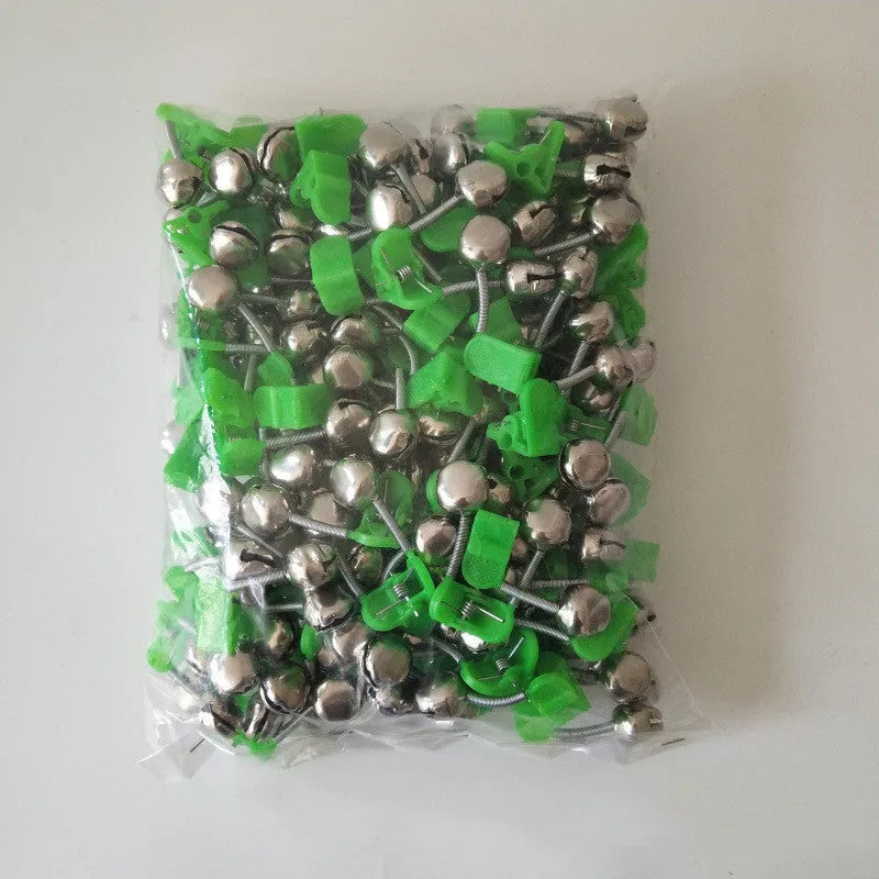 Two fishing bell bite alarms with LED lights, one green one red, clipped onto a fishing rod tip
