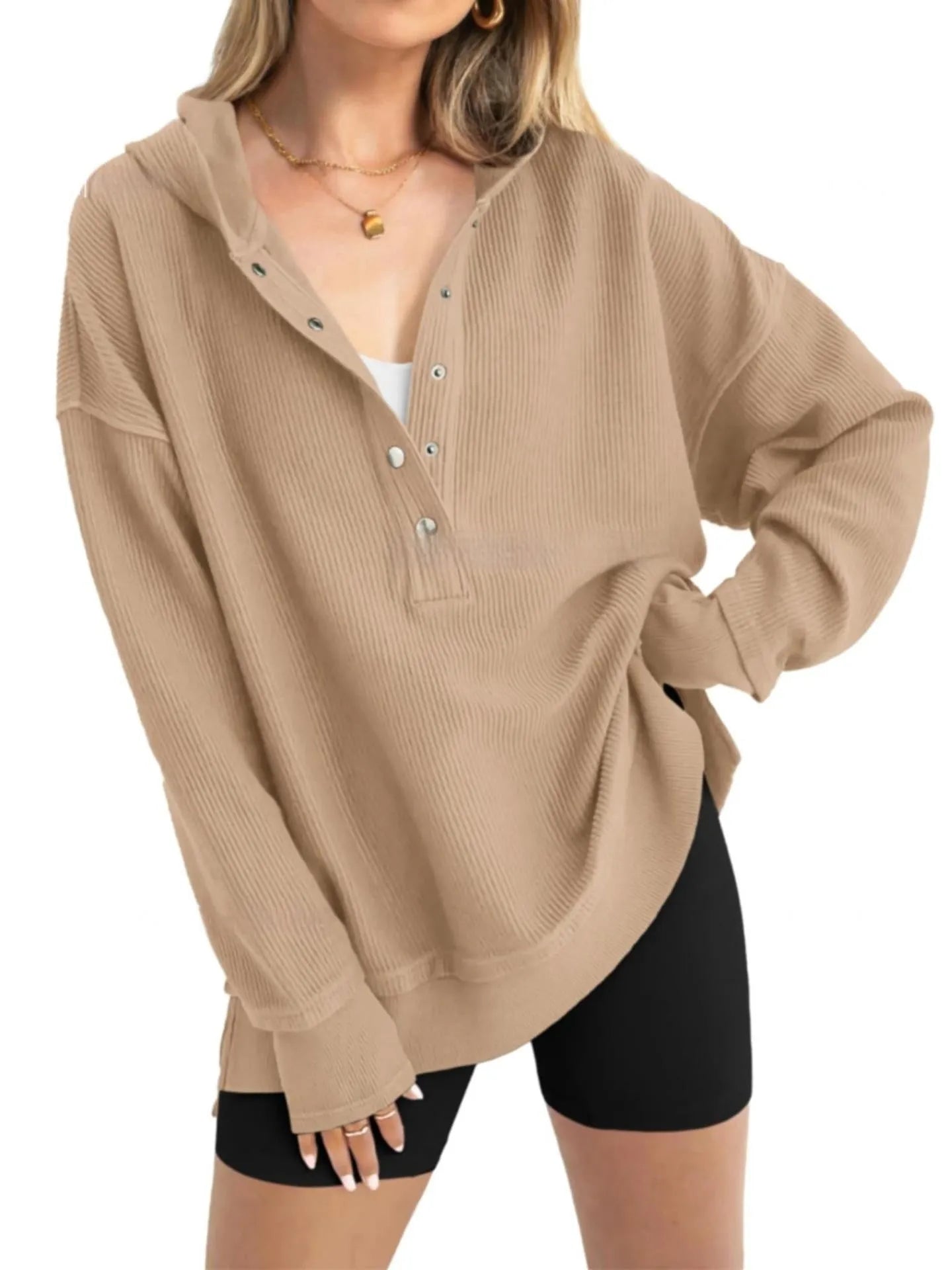 A woman wearing a loose peacock green pullover sweater with raglan sleeves.