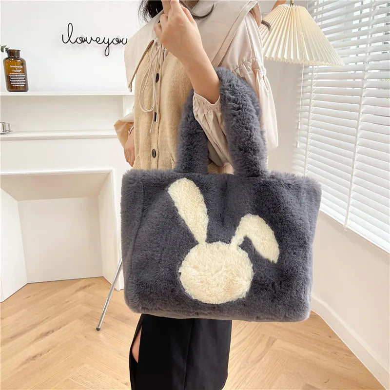Cartoon rabbit ears plush shoulder tote bag in a solid colour on a model.