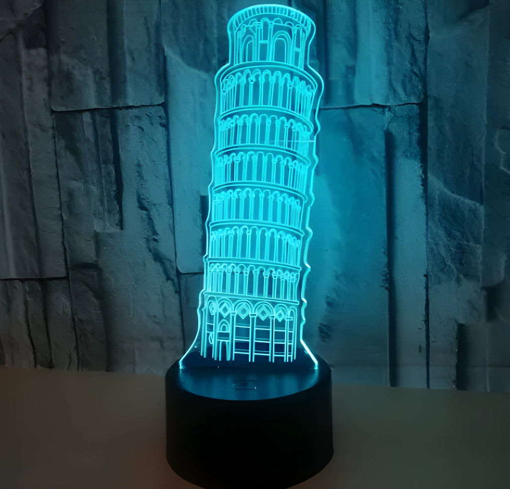 3D laser-cut Leaning Tower of Pisa nightlight glowing blue on a black base with a remote control.