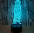 3D laser-cut Leaning Tower of Pisa nightlight glowing blue on a black base with a remote control.
